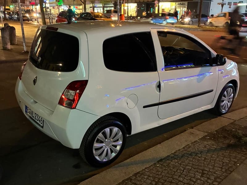 White customer car with Berlin plates at the roadside in Berlin in the evening